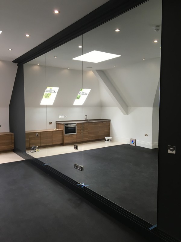 Frameless glass partition in loft conversion by Deptford glaziers